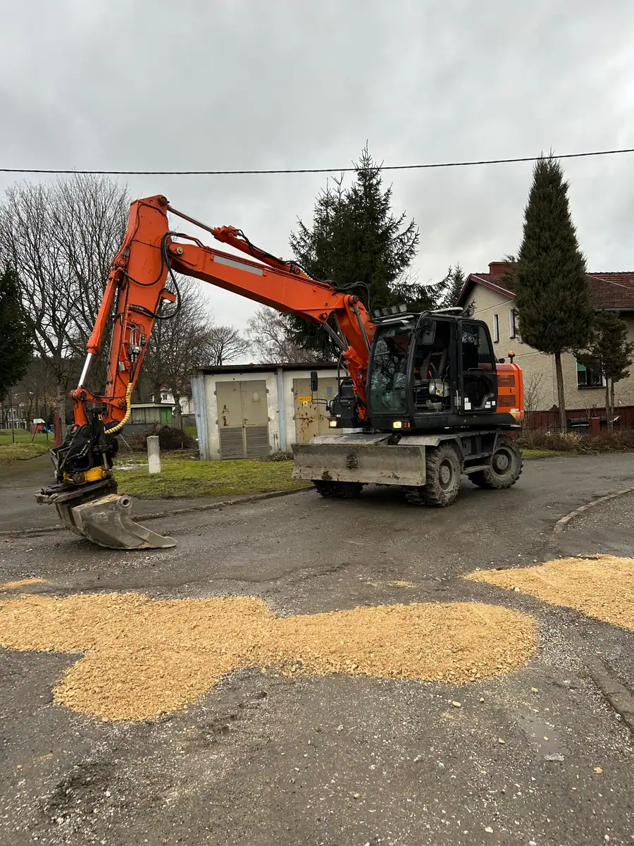 Koparka kołowa Hitachi Zaxis 140W z łyżką skarpową przy drodze zasypanej klińcem