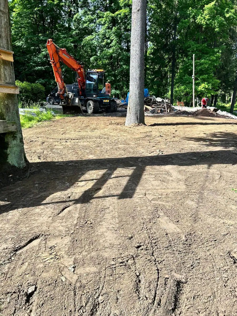 Koparka kołowa Hitachi Zaxis 140W na wyrównanym i zagęszczonym placu wśród drzew